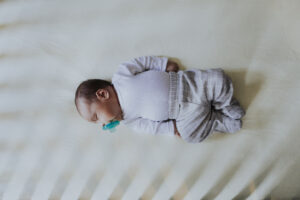 Peaceful baby sleeping in a crib on their back.