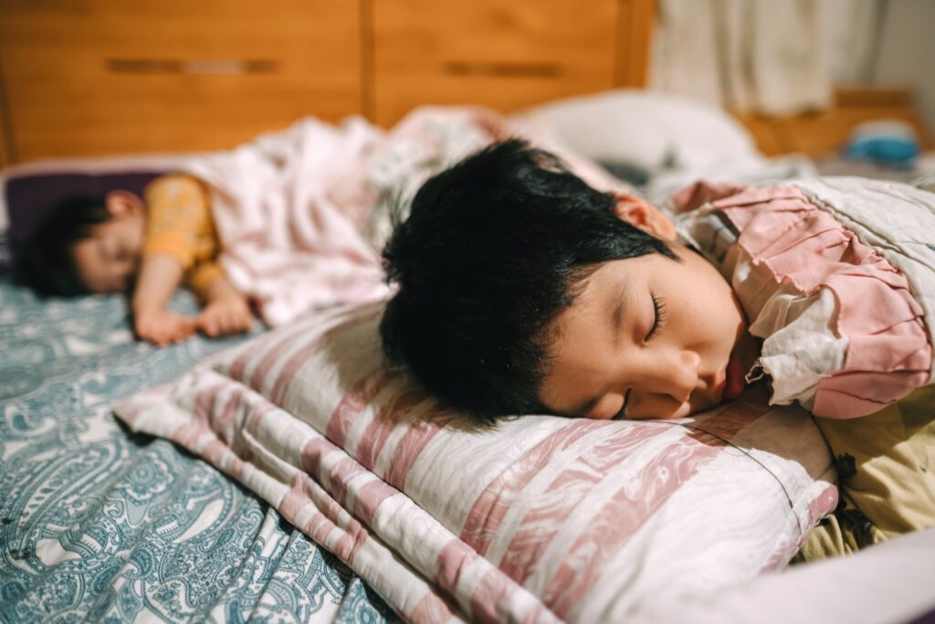 Two kids sleeping in bed