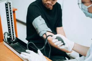 A doctor checks a patient's blood pressure using a BP cuff.