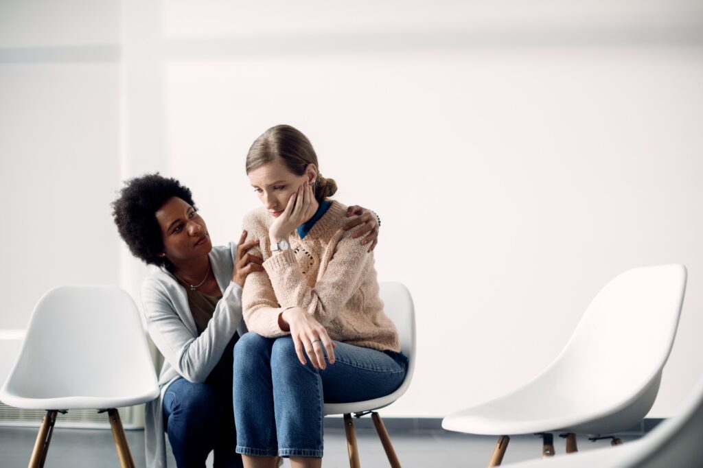 A woman comforts another woman who is emotionally upset.