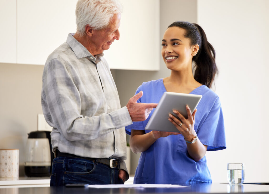 Shot of a young woman helping her elderly patient use a digital tablet.