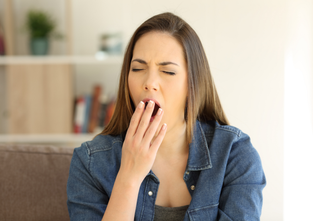 Tired woman yawning during the day.