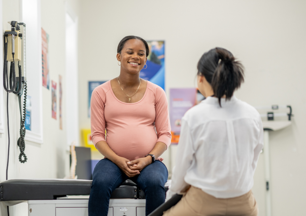 Pregnant woman talking with a health care provider during a prenatal visit
