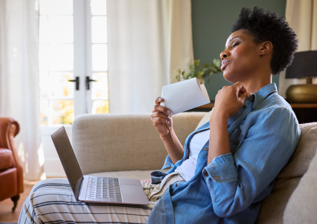 Woman using a fan to cool herself during a hot flash.