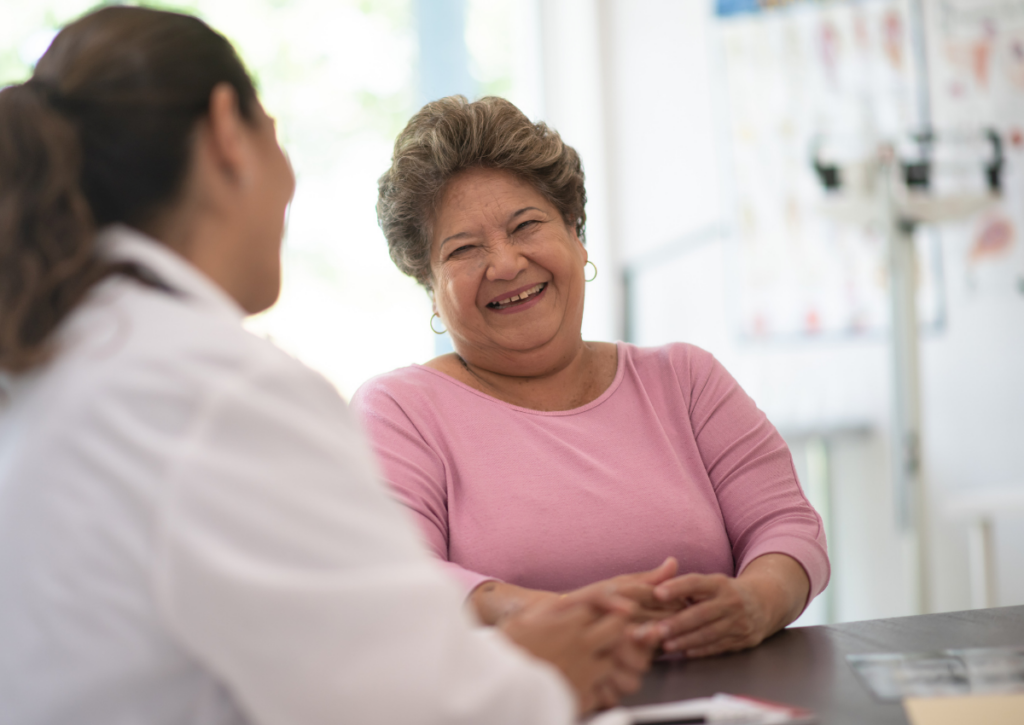 Smiling woman talking with a healthcare provider during an appointment.