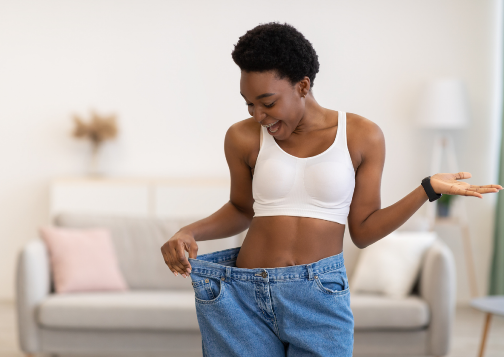 Woman checking the fit of her jeans after losing weight.